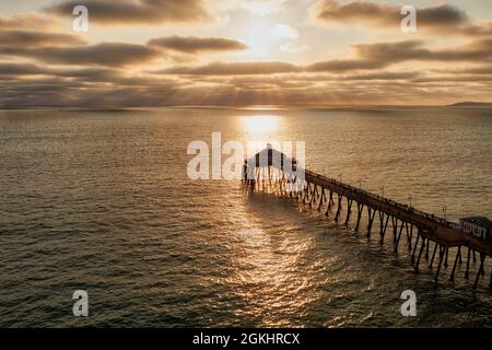 Beautiful sun rays and golden light on ocean and pier  Stock Photo