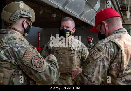 Col. Matthew Jones, 436th Airlift Wing commander, center, speaks with Capt. Michael Brickell, 436th Security Forces Squadron operations officer, left, and Tech. Sgt. Joseph Haller, 436th SFS noncommissioned officer in charge of Combat Arms Training and Maintenance, right, about the proper wear of safety gear at Dover Air Force Base, Delaware, April 27, 2021. The CATM facility is where service members receive training and qualify on various types of weapons. Stock Photo