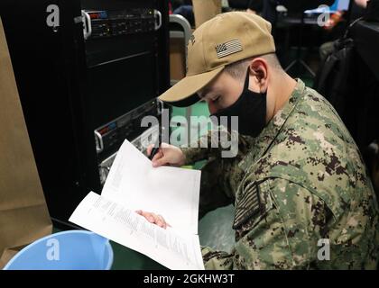 210427-N-TT639-1053 SAN DIEGO (April 27, 2021) Internal Communications Electrician Seaman Apprentice Francisco Basaldua performs maintenance on the SITE TV racks aboard the amphibious assault ship USS Tripoli (LHA 7), April 27. Tripoli is an America-class amphibious assault ship homeported in San Diego. Stock Photo