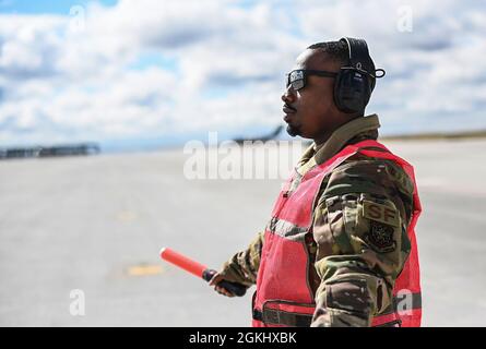 Senior Airman Antoine Barnes, 821st Contingency Response Squadron fire team member, marshals a C-17 Globemaster III from Joint Base Lewis-McChord, Washington, April 27, 2021, on the flight line at Mountain Home AFB, Idaho. Barnes participated in exercise Rainier War, testing his abilities to employ air combat capabilities during a time of potentially imminent foreign aggression. Stock Photo