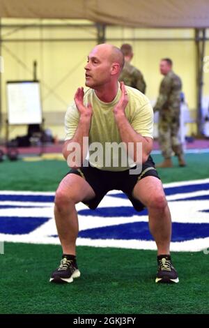 SCHRIEVER AIR FORCE BASE, Colo. -- Lance Thibault, National Space Defense Center senior enlisted leader, completes air squats during the U.S. Space Command monthly warrior physical training session at the Schriever Air Force Base indoor running track April 28.  Joint Task Force-Space Defense and USSPACECOM teams completed multiple runs along with hundreds of push ups, rowers, over head presses and air squats. Stock Photo