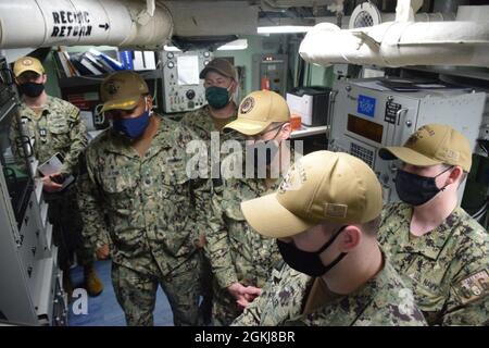 210430-N-PS0730-1023: Global Positioning Navigation and Timing Service (GPNTS) technicians, ET2 Austin Miller and ET2 Jacob Hill, demonstrate the user interface for Rear Adm. John Okon, Cmdr. Ray Glenn, and CW02 Mike Pruitt. Okon visited the USS Gonzalez (DDG 66) to discuss with technicians about the operation and maintenance of the GPNTS system from a technicians point of view in order to provide insight for the future development of the system. Stock Photo