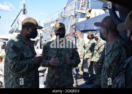 210430-N-PS0730-1007: Rear Adm. John Okon speaks with Cmdr. Ray Glenn, the commanding officer of USS Gonzalez (DDG 66), and CW02 Mike Pruitt, the Electronic Materials Officer. Okon visited Gonzalez to discuss with technicians about the operation and maintenance of the Global Positioning Navigation and Timing Service (GPNTS) system from a technicians point of view in order to provide insight for the future development of the system. Stock Photo