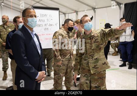 U.S. Air Force Staff Sgt. Joseph Hynson, right, a St. Mary’s County, Maryland native, explains the vaccination process to Congressman Anthony Gregory Brown, who represents Maryland’s 4th Congressional District, at the federally-run pilot Community Vaccination Center at the Greenbelt Metro Station in Greenbelt, Maryland, April 30, 2021. U.S. Northern Command, through U.S. Army North, remains committed to providing continued, flexible Department of Defense support to the Federal Emergency Management Agency as part of the whole-of-government response to COVID-19. Stock Photo