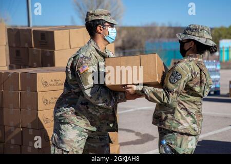 Soldiers from the Arizona Army National Guard distribute food and supplies at a drive-through food bank in Ft. Defiance, Ariz. on the Navajo Nation, April 30, 2021. More than 900 of Arizona’s Citizen-Soldiers and Airmen continue to travel all over the state to assist communities at vaccination sites and food banks. Stock Photo