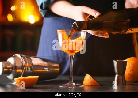 Woman preparing tasty aperol spritz cocktail at table Stock Photo