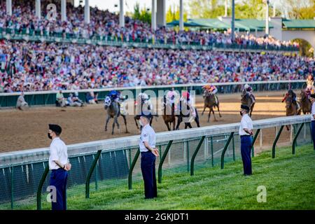 Soldiers from the 75th Troop Command stand guard alongside the rail as the race horses advance towards the finish line of the 147th annual Kentucky Derby at Churchill Downs in Louisville, Ky., May 1, 2021. Soldiers with the 75th and Kentucky Airmen augmented the Louisville Metro Police Department and Churchill Downs security to provide a safe and secure running of the 147th Kentucky Derby. Stock Photo