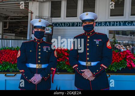 Marine Corps Staff Sgt. Kyle Bogel, left, and Sgt. Kelly Anderson, right, recruiters with Recruiting Station Louisville, guard the Garland of Roses before presenting them to the winning horse at the Kentucky Derby in Louisville, Ky, May 1, 2021. The “Garland of Roses,” is the prize given the winning thoroughbred at the Kentucky Derby. Stock Photo