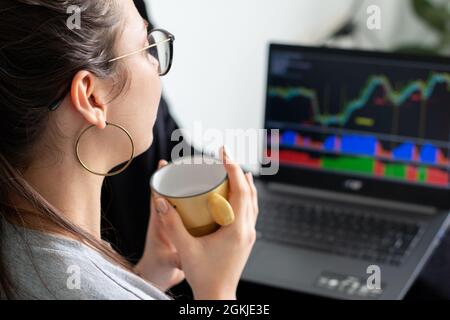 Woman looking at trading charts on her laptop. Stock Photo