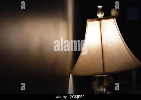 A lamp shining in a dark room Stock Photo