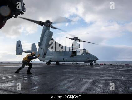 210503-N-LD903-1140  NORTH PACIFIC OCEAN (May 3, 2021) – U.S. Navy Chief Aviation Boatswain’s Mate (Handling) Matthew Beilke directs a U.S. Marine Corps MV-22 Osprey, assigned to Marine Medium Tiltrotor Squadron 164 (Reinforced), 15th Marine Expeditionary Unit, during a takeoff aboard the amphibious assault ship USS Makin Island (LHD 8) in support of Northern Edge 2021. Approximately 15,000 U.S. service members are participating in a joint training exercise hosted by U.S. Pacific Air Forces May 3-14, 2021, on and above the Joint Pacific Alaska Range Complex, the Gulf of Alaska, and temporary m Stock Photo
