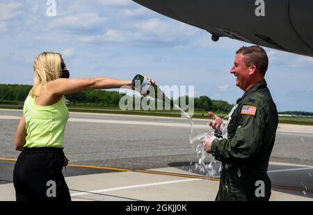 Christie Jones pours champagne on her husband, Col. Matthew Jones, 436th Airlift Wing commander, following his fini flight at Dover Air Force Base, Delaware, May 4, 2021. A “fini flight” is an Air Force tradition where an Airman and their family celebrate their final flight. Stock Photo