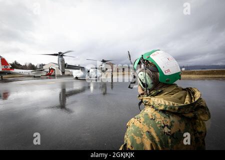 A U.S. Marine with Medium Tiltrotor Squadron 764, 4th Marine Aircraft Wing, observes an MV-22 Osprey before takeoff during Arctic Care 2021 in Kodiak, Alaska, on May 5, 2021. Marines from 4th Marine Aircraft Wing, 4th Marine Logistics Group and Force Headquarters Group are providing logistical support for the exercise, which provides cost-free care to residents of Kodiak Island, Alaska. Stock Photo