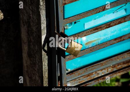 Golden padlock on iron door closing water measuring box. Historic center of Salvador, Bahia, Brazil. Stock Photo