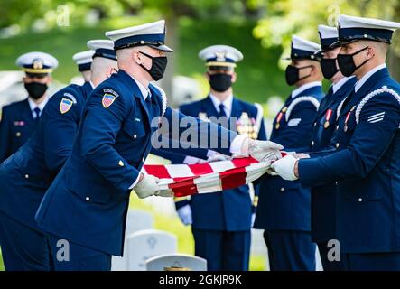 Members of the U.S. Coast Guard Honor Guard, a drummer from the U.S. Navy Ceremonial Band, and the 3d U.S. Infantry Regiment (The Old Guard) Caisson Platoon conduct modified military funeral honors with funeral escort for retired U.S. Coast Guard Rear Adm. Marshall E. Gilbert in Section 33 of Arlington National Cemetery, Arlington, Virginia, May 6, 2021.     Gilbert was a distinguished leader in the U.S. Coast Guard and helped create the technical standards for electronic communications, navigation, and distress alerting used worldwide.       Gilbert's spouse, Melinda Gilbert, received the fla Stock Photo