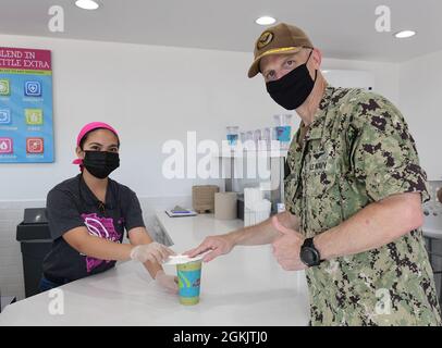 210507-N-QB805-0643  CAMP LEMONNIER, Djibouti (May 7, 2021)-  U.S. Navy Capt. Kyle Schuman, commanding officer, Camp Lemonnier, Djibouti, purchases a smoothie from Camp Lemonnier’s newest addition, Planet Smoothie, May 7, 2021. Camp Lemonnier is an operational installation that enables U.S., allied and partner nation forces to be where and when they are needed to ensure security in Europe, Africa and Southwest Asia. Stock Photo