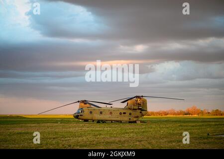 U.S. Army Soldiers from Bravo Company, 2nd General Support Aviation Battalion, 1st Combat Aviation Brigade watch as the sun sets while providing 'FATCOW' refueling operations during Swift Response 21, May. 8, 2021, at Boboc Airfield, Romania. Swift Response 21 is a Defender Europe 21 linked exercise and is an annual large-scale US Army-led, multinational, joint exercise designed to build readiness and interoperability between U.S., NATO, and partner militaries. Stock Photo