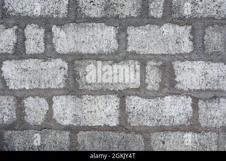 concrete wall with cement blocks and plaster, light gray mortar brick layers surface, masonry work wallpaper, background, texture Stock Photo