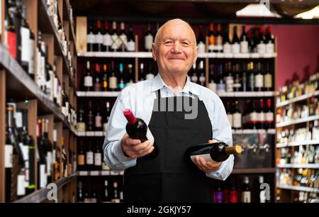 vintner offering wine in modern wineshop Stock Photo