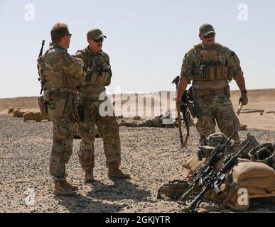 U.S. Army Capt. Samuel A. Palmer, Spc. Richard G Olmstead III and Spc. Michael L. Halley, all assigned to D Company 3-172 Mountain Infantry, Task Force Iron Valor, talk while at a rifle range near Camp Buehring, Kuwait, May 9, 2021. During a two-day live-fire exercise, Soldiers trained on individual weapons and crew-served weapon systems.