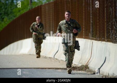 U.S. Army Spc. Jacob Jesperson, assigned to 19th Special Forces Group (Airborne), leads a team run while participating in the Spc. Hilda I. Clayton Best Combat Camera Competition at Fort George G. Meade, Md., May 10, 2021. The Spc. Hilda I. Clayton Best Combat Camera Competition is an annual event hosted by 55th Signal Company (Combat Camera) open to all branches of the military and multi-national partners that tests physical, tactical and technical skills required of visual information specialists. Stock Photo