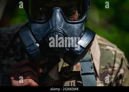 U.S. Army Spc. Ramon Wright, assigned to 3rd Psychological Operations Battalion, 8th Psychological Operations Group, fits his gas mask while participating in the Spc. Hilda I. Clayton Best Combat Camera Competition at Fort George G. Meade, Md., May 10, 2021. The Spc. Hilda I. Clayton Best Combat Camera Competition is an annual event hosted by 55th Signal Company (Combat Camera) open to all branches of the military and multi-national partners that tests physical, tactical and technical skills required of visual information specialists. Stock Photo