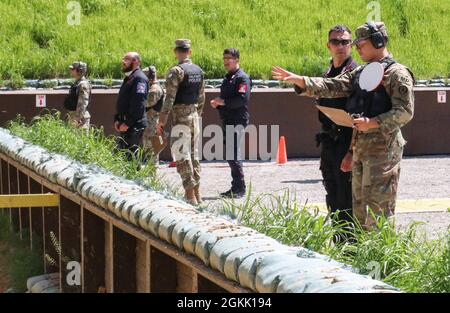 U.S. and international military police officers assigned to the NATO-led Kosovo Force walk through instructions for a pistol range during an MP qualification range day at Camp Bondsteel, Kosovo, on May 10, 2021. MPs from across KFOR came together to celebrate National Police Appreciation Week. Stock Photo