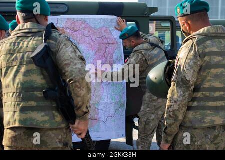 A Turkish Armed Forces soldier assigned to Regional Command-East, Kosovo Force, briefs a route plan at Camp Bondsteel before conducting a night patrol in Ranilluk/Ranilug, Kosovo, on May 11, 2021. The soldiers cooperated with local Kosovo Police to conduct a routine patrol and set up a checkpoint to search for illegal contraband. Stock Photo