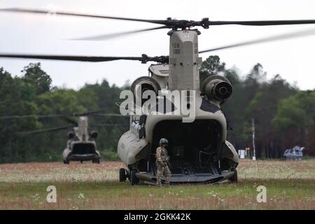 U.S. Army National Guard Soldiers with Det. 1 Company B, 2-238th General Support Aviation Battalion, South Carolina National Guard, complete their gunnery training, with a CH-47F Chinook helicopter at Poinsett Range Complex, South Carolina, May 10, 2021. The training included, both day and night, live-fire tables focused on safety, accuracy, and crew coordination. This type of training is critical to the combat mission of the unit. The helicopter serves the South Carolina National Guard’s dual mission as a medium-heavy cargo platform, unarmed during disaster relief operations, as well as armed Stock Photo