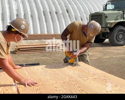200511-N-SK929-1004 SANTA RITA, Guam (May 11, 2021) Seabees assigned to Naval Mobile Construction Battalion (NMCB) 11 Det. Guam cut plywood while prefabricating the forms for reinforced concrete columns on GM18-877: Convert Existing Outhouse to Restroom. The project will enable watchstanders at the Naval Magazine on Guam to maintain two person integrity with a permanent head facility adjacent to their post. NMCB 11 Det. Guam is forward-deployed to execute construction, humanitarian assistance, theater security cooperation, and support Major Combat Operations in the U.S. 7th Fleet areas of oper Stock Photo