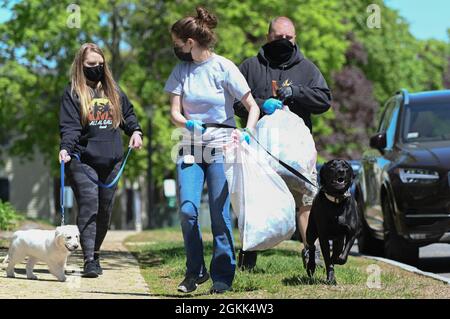 Staff Sgt. Noel Lynch, from left, Airman 1st Class Brittany Senft and Weston Dean, members of the 66th Security Forces Squadron, pick up trash during a cleanup event at Hanscom Air Force Base., Mass., May 12. Stock Photo