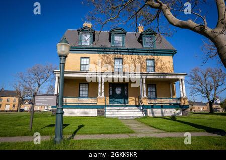 Lieutenant’s Quarters History House at Fort Hancock, Gateway National Recreation Area at Sandy Hook, N.J., May 13, 2021. The original post, designed to garrison 400 Soldiers who supported the coastal defense gun batteries, consisted of 32 “butter brick” Colonial Revival architecture structures built around a parade ground. Construction began in 1898, with enlisted men housed in barracks while married noncommissioned officers and officers lived in separate quarters. By 1911, the Fort had a commissary, bakery, chapel, laundry, school, tailor shop, and a Young Men’s Christian Association for the Stock Photo