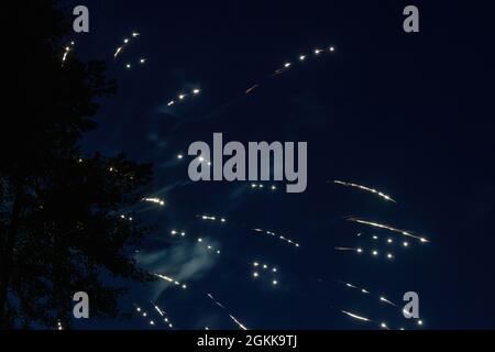 white firework sparks against dark blue summer sky during celebration Stock Photo