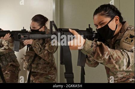 U.S. Army Reserve Spc. Jody Padgett, left, and Pvt. Dulce Higareda, both in the 647th Regional Support Group (RSG), 416th Theater Engineer Command, based in Wichita, Kan., practice the unsupported standing position with empty magazines in their assigned weapons during a new rifle qualification class at the Lanny J. Wallace Reserve Center in Wichita, May 14, 2021. The Soldiers practiced this position and the  kneeling and prone positions and transitioning between each position while employing empty magazines on their own. Stock Photo