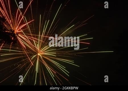 red and green sparks from fireworks in night sky celebration Stock Photo