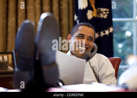President Barack Obama smiles while talking with Russian President Dmitry Medvedev on the phone in the Oval Office, Saturday, Dec. 12, 2009. (Official White House Photo by Pete Souza) This official White House photograph is being made available only for publication by news organizations and/or for personal use printing by the subject(s) of the photograph. The photograph may not be manipulated in any way and may not be used in commercial or political materials, advertisements, emails, products, promotions that in any way suggests approval or endorsement of the President, the First Family, or th Stock Photo