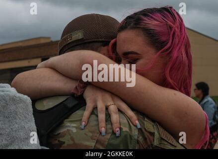 Senior Airman Justin Barnes, 317th Aircraft Maintenance Squadron crew chief, hugs his wife Hannah after returning home from a deployment at Dyess Air Force Base, Texas, May 15, 2021. Airmen with the 317th Airlift Wing provided humanitarian efforts, aeromedical evacuations and combat delivery through tactical airlift and airdrop operations during their deployment. Stock Photo