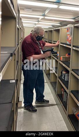 Hal Casey, director of NAVSUP 065, Department of the Navy (DoN) and Department of Defense (DoD) Systems for Naval Supply Systems Command, uses the Naval Autonomous Data Collection System in a warehouse during test and evaluation. Casey was able to conduct an inventory on roughly 3,400 individual items in less than 1.5 hours. Stock Photo