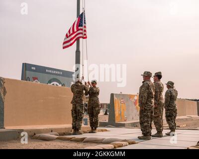 Soldiers from Headquarters Support Company, 640th Aviation Support Battalion, lower the Colors after Retreat at Camp Buehring, Kuwait. Stock Photo