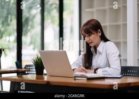 Shot of asian woman watching webinar write notes study online with online teacher, african female student learning language computer course on laptop Stock Photo
