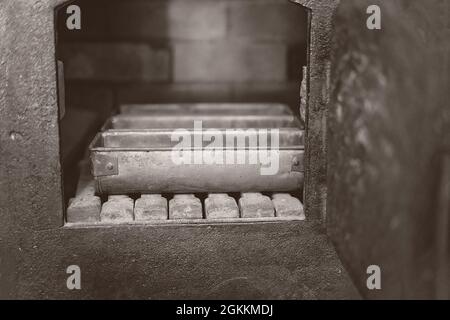 Bread tins in a vintage brick oven - monotone image in intentional shallow depth of field Stock Photo