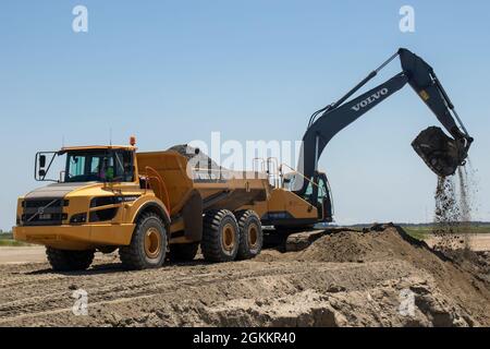 Heavy equipment is used to move recently dredged up sand to other portions of the Craney Island Dredged Material Management Area. The sand, which is being repurposed, was originally placed in the facility from dredging the navigation channels in the Hampton Roads region. The Craney Island facility is a 2,500-acre confined dredged material disposal site located in Portsmouth, VA., and provides a long-term material dredged from the channels and ports in the Hampton Roads area. Stock Photo