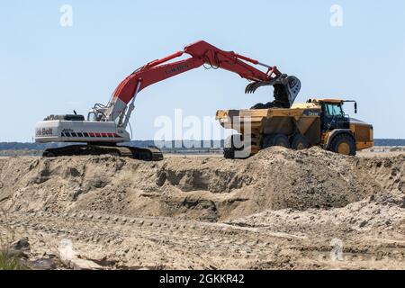 Heavy equipment is used to move recently dredged up sand to other portions of the Craney Island Dredged Material Management Area. The sand, which is being repurposed, was originally placed in the facility from dredging the navigation channels in the Hampton Roads region. The Craney Island facility is a 2,500-acre confined dredged material disposal site located in Portsmouth, VA., and provides a long-term material dredged from the channels and ports in the Hampton Roads area. Stock Photo