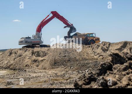 Heavy equipment is used to move recently dredged up sand to other portions of the Craney Island Dredged Material Management Area. The sand, which is being repurposed, was originally placed in the facility from dredging the navigation channels in the Hampton Roads region. The Craney Island facility is a 2,500-acre confined dredged material disposal site located in Portsmouth, VA., and provides a long-term material dredged from the channels and ports in the Hampton Roads area. Stock Photo