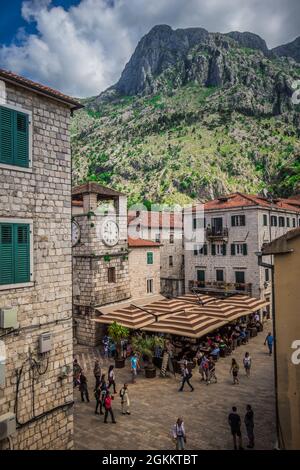Town square in Kotor Montenegro with the Torre del reloj and people sitting at an outdoor cafe. Stock Photo