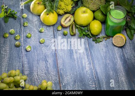Healthy green fruits and vegetables: lime, kiwi, lettuce, cucumber, avocado, broccoli, grapes, apples etc and green vegetables smoothie in the jar on Stock Photo