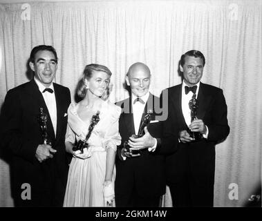 ANTHONY QUINN (Best Supporting Actor of 1956 for his role as Paul Gauguin in Lust For Life) DOROTHY MALONE (Best Supporting Actress for Written on the Wind) YUL BRYNNER (Best Actor for The King and I) and CARY GRANT (with the Oscar he accepted for INGRID BERGMAN for Best Actress in Anastasia) at the 29th Academy Awards at RKO Pantages Theatre on Wednesday March 27th 1957 publicity from Twentieth Century Fox Stock Photo
