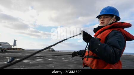 PACIFIC OCEAN (May 22, 2021) – U.S. Navy Seaman Trinity Gotcher, from North Port, Fla., pulls a phone-and-distance line aboard the aircraft carrier USS Theodore Roosevelt (CVN 71) during a replenishment-at-sea, May 22, 2021. The Theodore Roosevelt Carrier Strike Group is on a scheduled deployment conducting routine operations in U.S. 3rd Fleet. Stock Photo