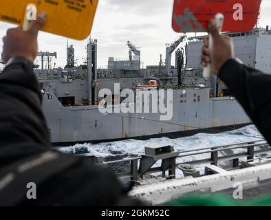 210522-N-RO855-1213    PACIFIC OCEAN (May 22, 2021) – U.S. Navy Seaman Minson Octavius, from Atlanta, signals the fleet replenishment oiler USNS Richard Byrd (T-AKE 4) using a signal paddle during a replenishment-at-sea aboard the aircraft carrier USS Theodore Roosevelt (CVN 71), May 22, 2021. The Theodore Roosevelt Carrier Strike Group is on a scheduled deployment conducting routine operations in U.S. 3rd Fleet. Stock Photo