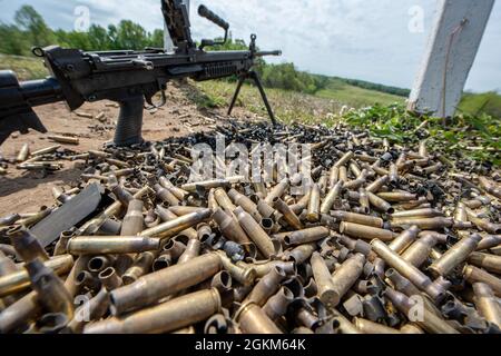 A pile of empty bullet casings lay on the ground after being fired from the M249 automatic rifle during a heavy weapons training event at Fort Custer in Augusta, Michigan, May 22, 2021. The training gives Airmen hands-on experience with various heavy weapons, ensuring they are prepared for any situation around the world. Stock Photo